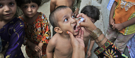 En grupp barn i staden Lahore i Pakistan får vaccin mot polio. FOTO: K.M. Chaudary/SCANPIX